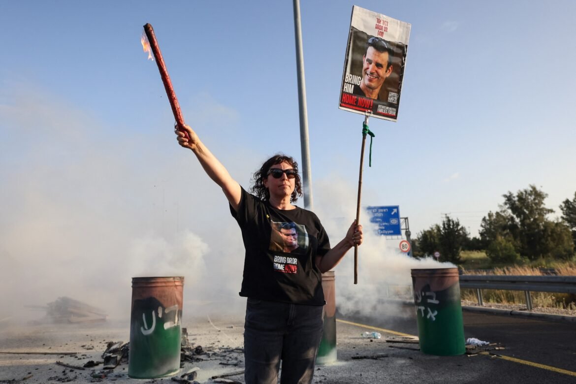 PHOTO: A woman holds a sign with a photograph of Israeli hostage Dror Or on April 19, 2024, during a protest calling for his release. 